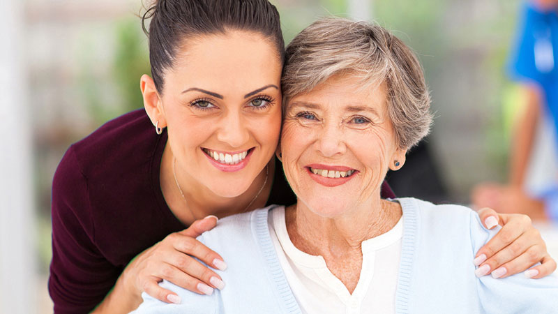 Closeup portrait of a daughter embracing her mother.