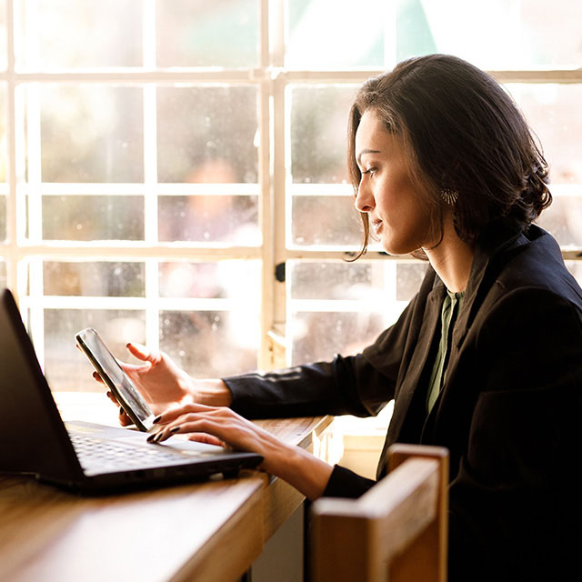 mujer empresaria trabajando con móvil y laptop